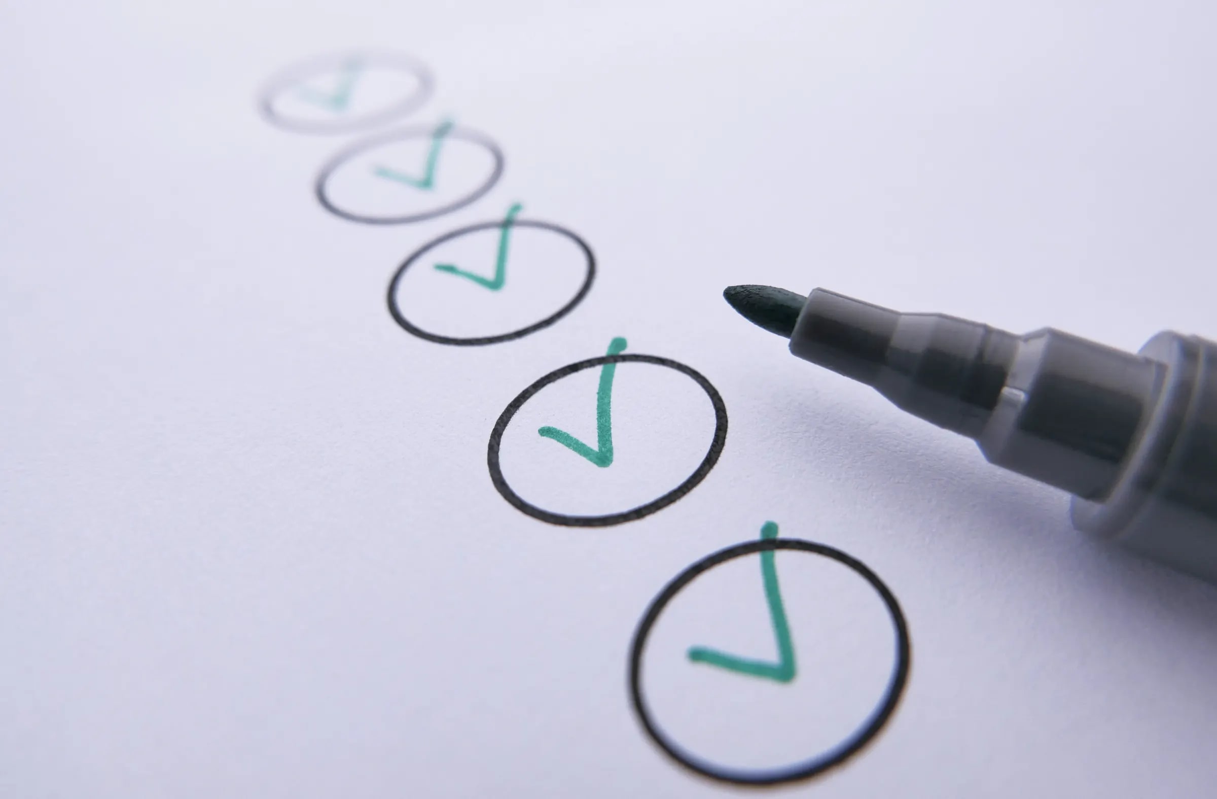 A checklist ticked off with a green marker, the marker lying beside it