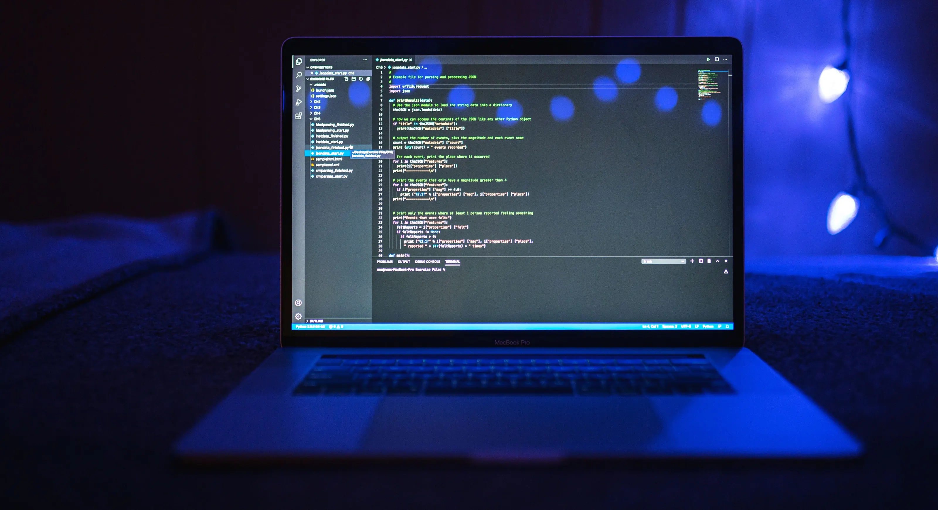 A laptop showing program code in a dark room