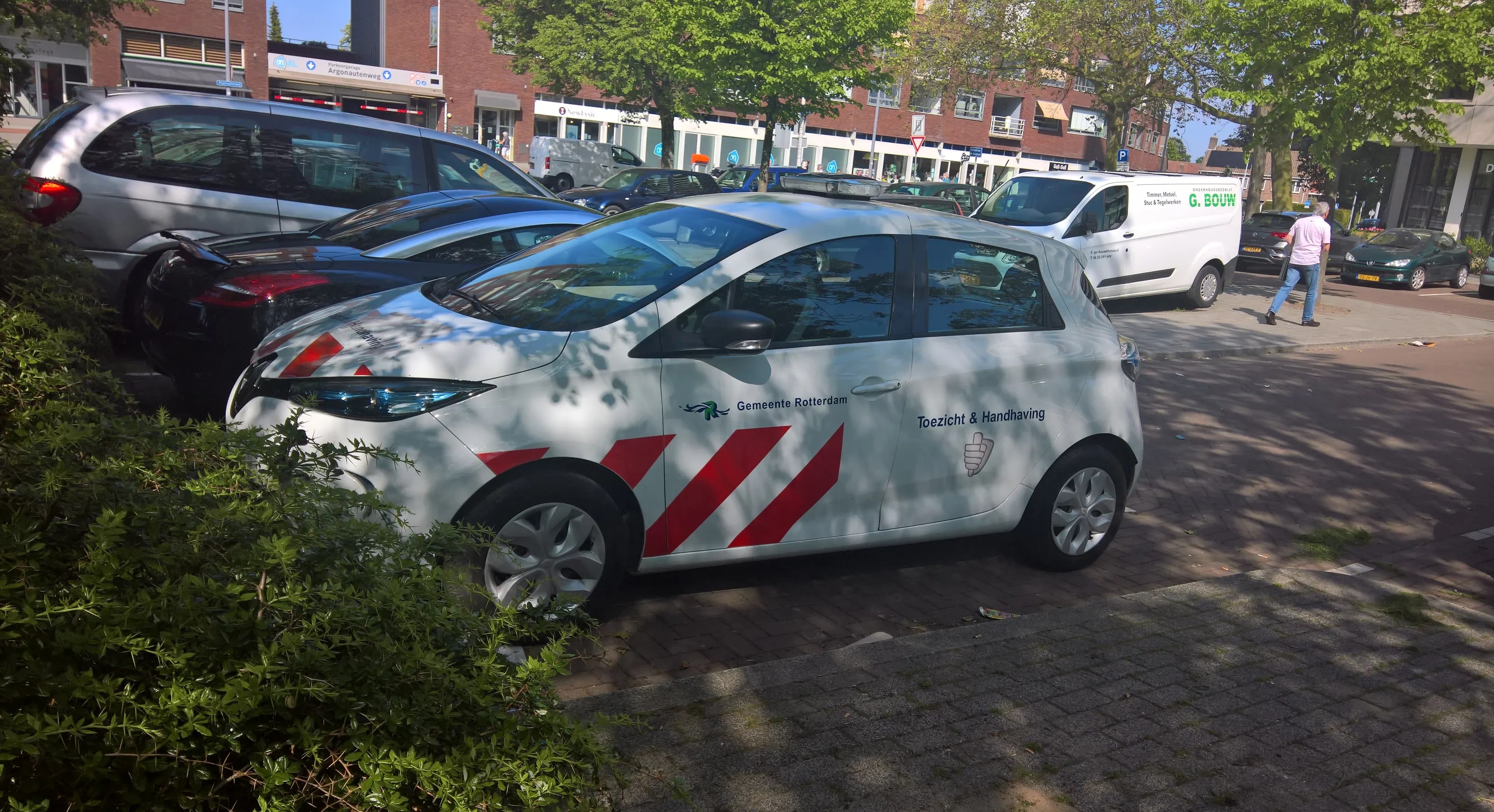 A Gemeente Rotterdam enforcement car parked along a shopping street