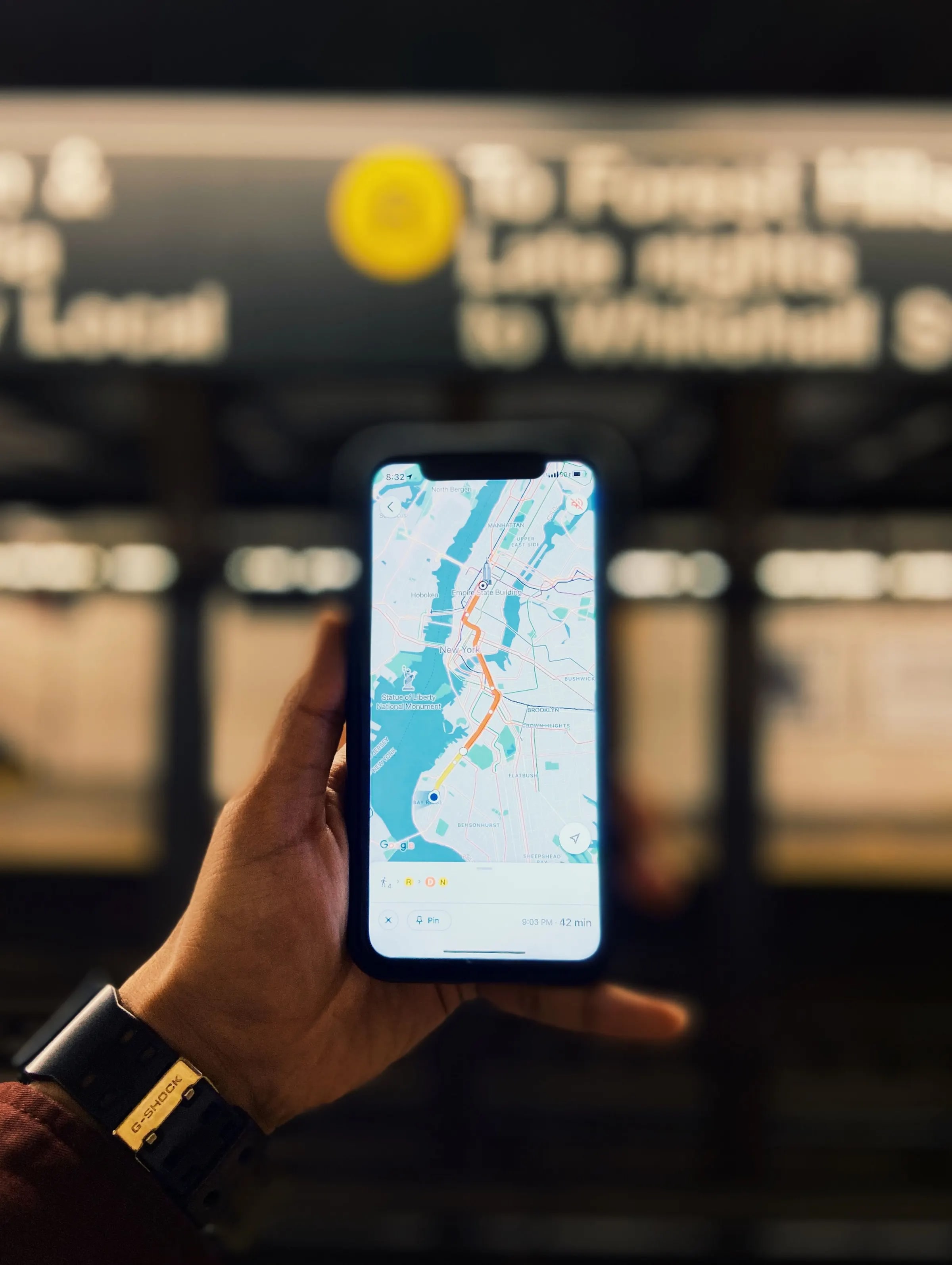 A hand holding a phone showing a map app with a route
