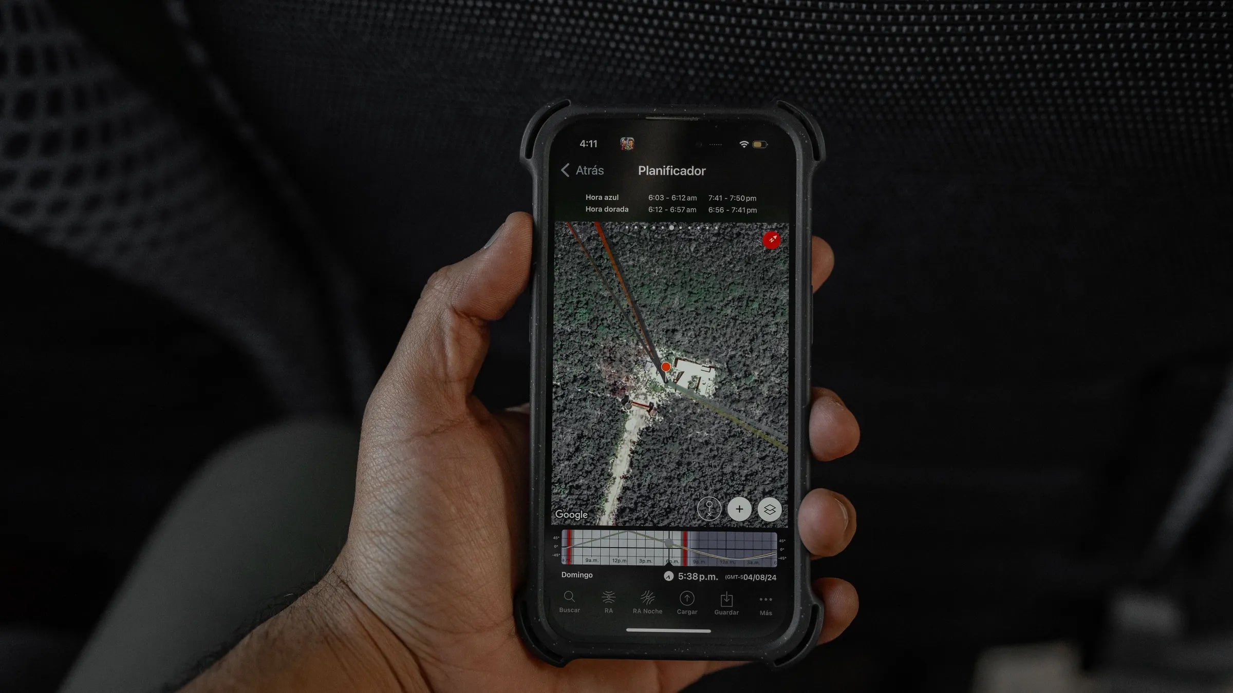 Een hand in een auto houdt een telefoon met een kaartweergave vast