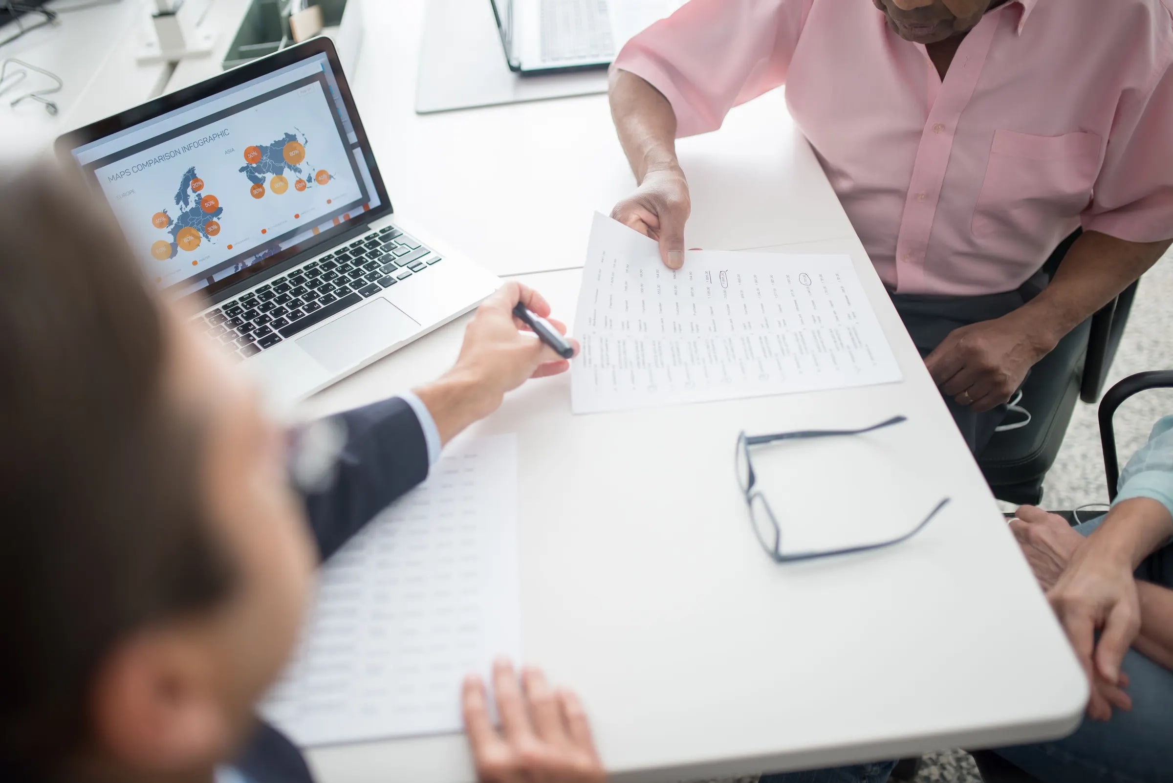 An adviser goes through a document with an elderly couple at a desk