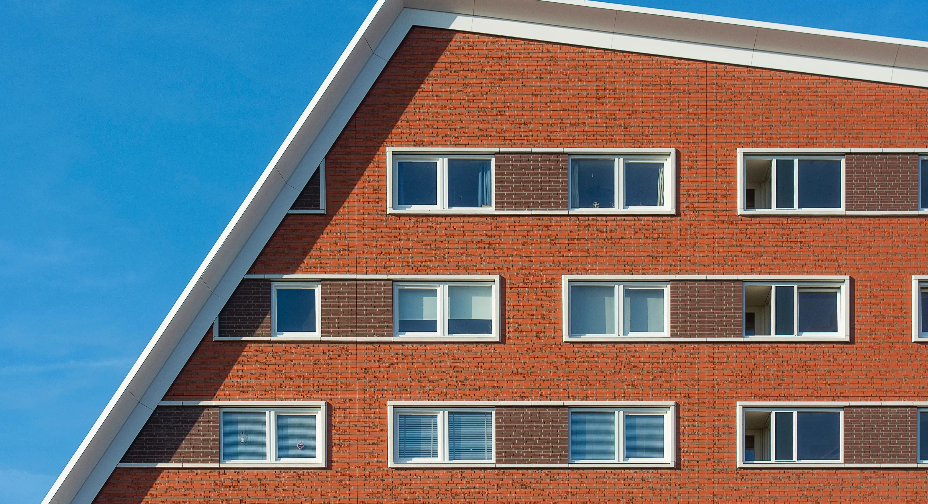 The facade of a modern apartment building in The Hague against a blue sky