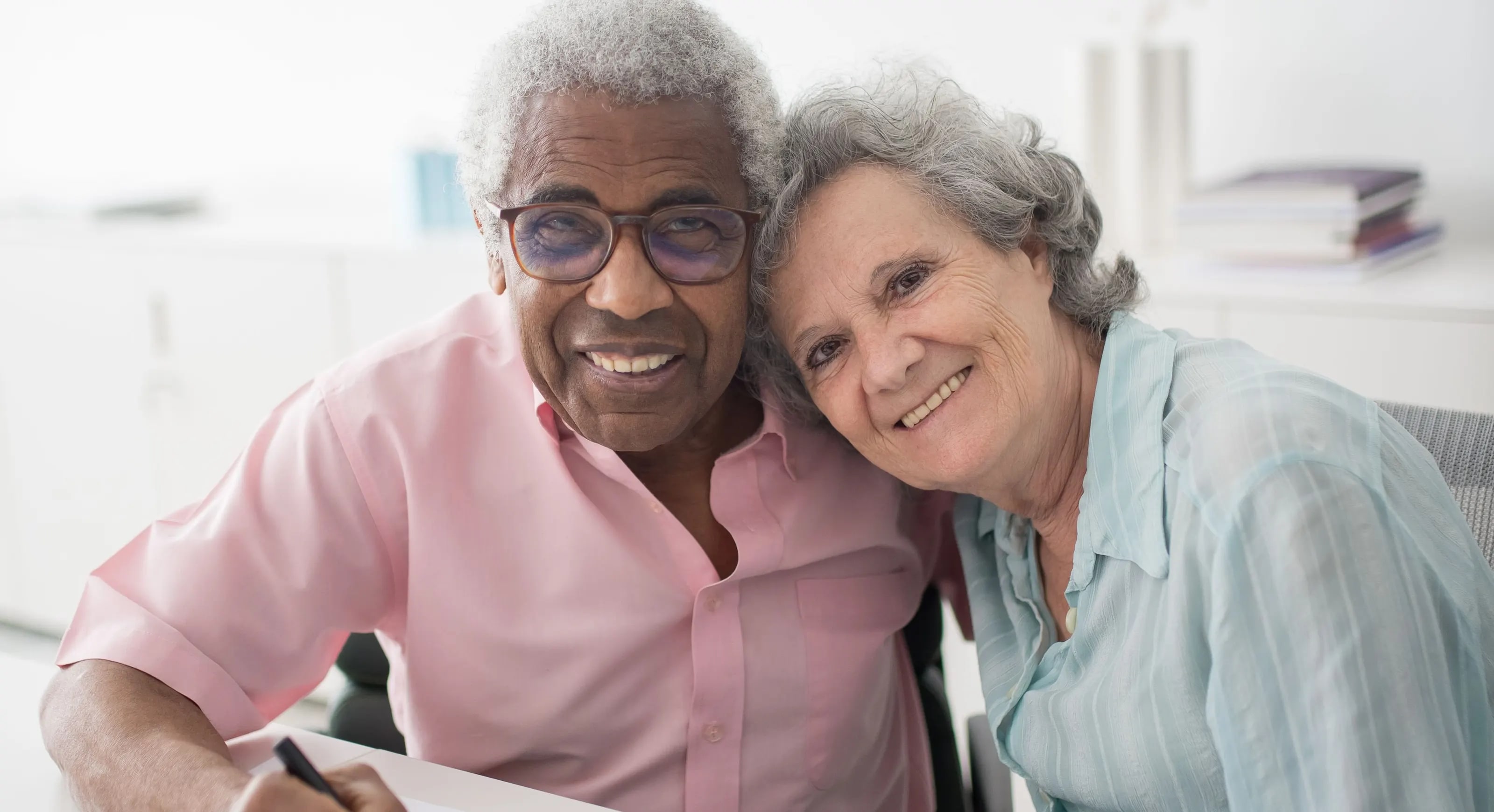 An elderly couple signing a document together