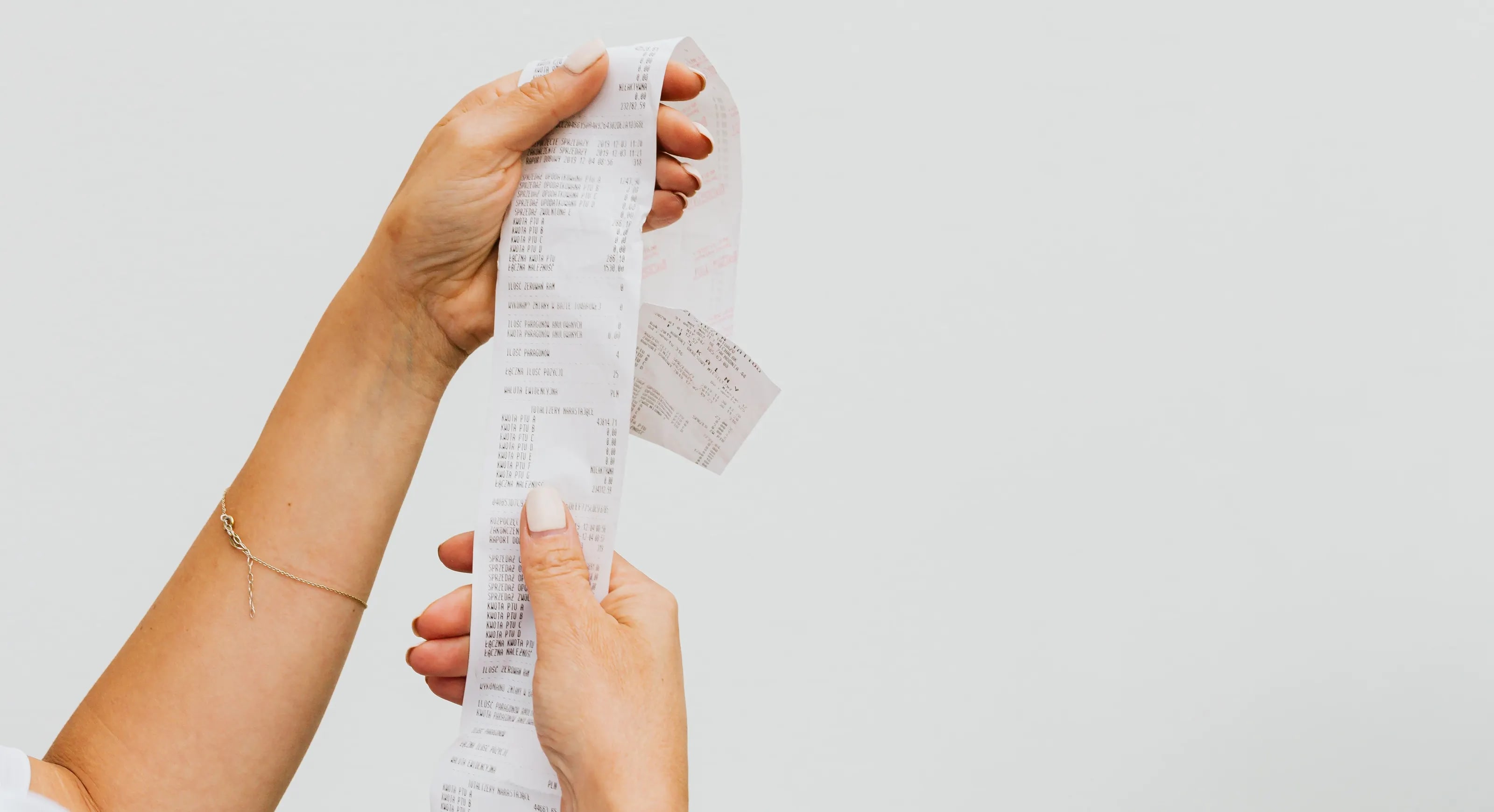 Two hands holding a long paper receipt
