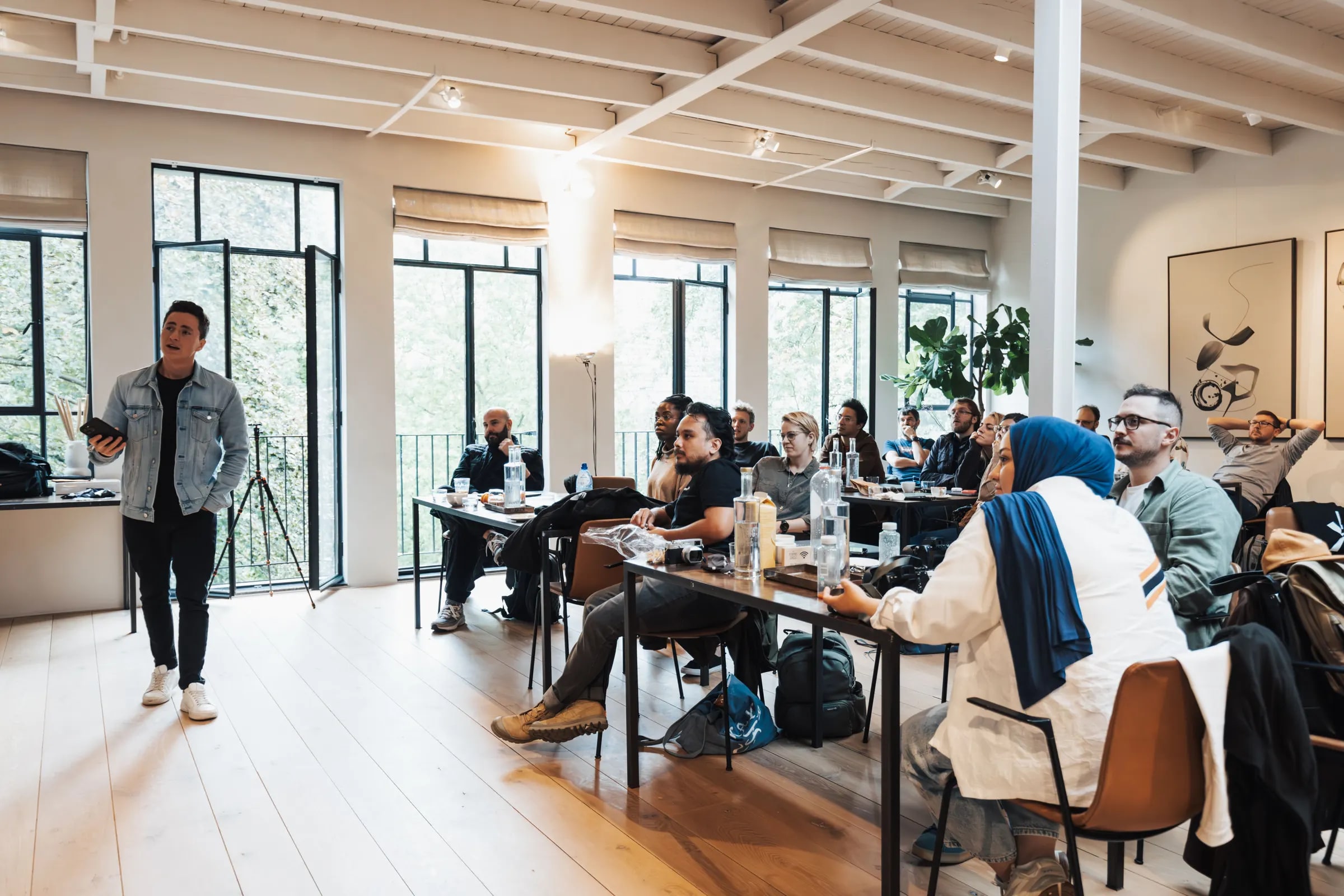A trainer giving a presentation to a group in a bright room