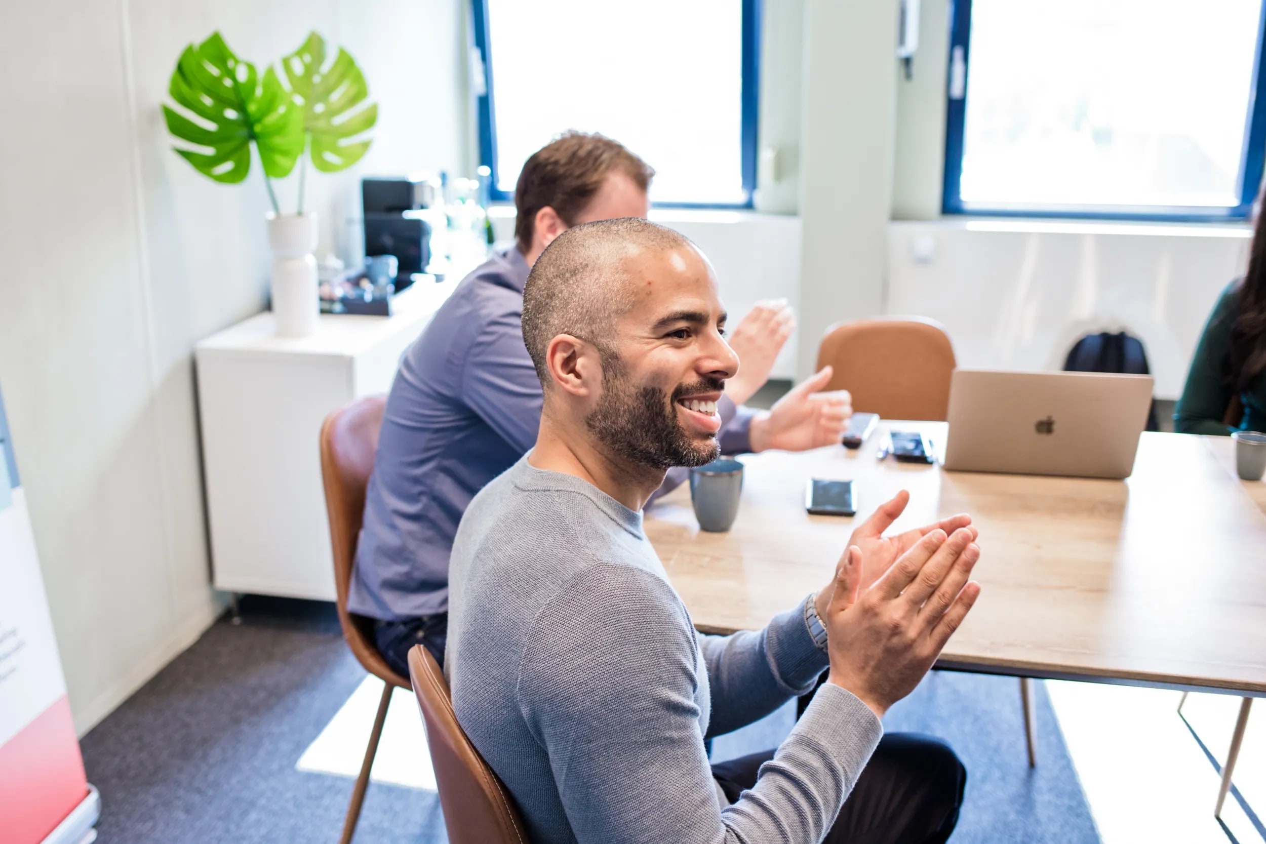 A colleague laughing during a meeting at the office table