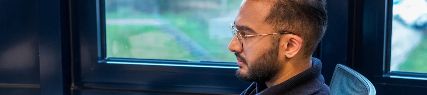 Een ontwikkelaar van JAM-IT werkt geconcentreerd bij het raam