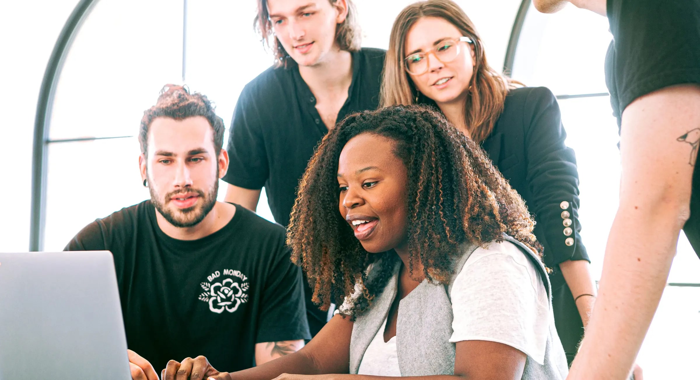 Een groep collega's kijkt samen naar een laptop