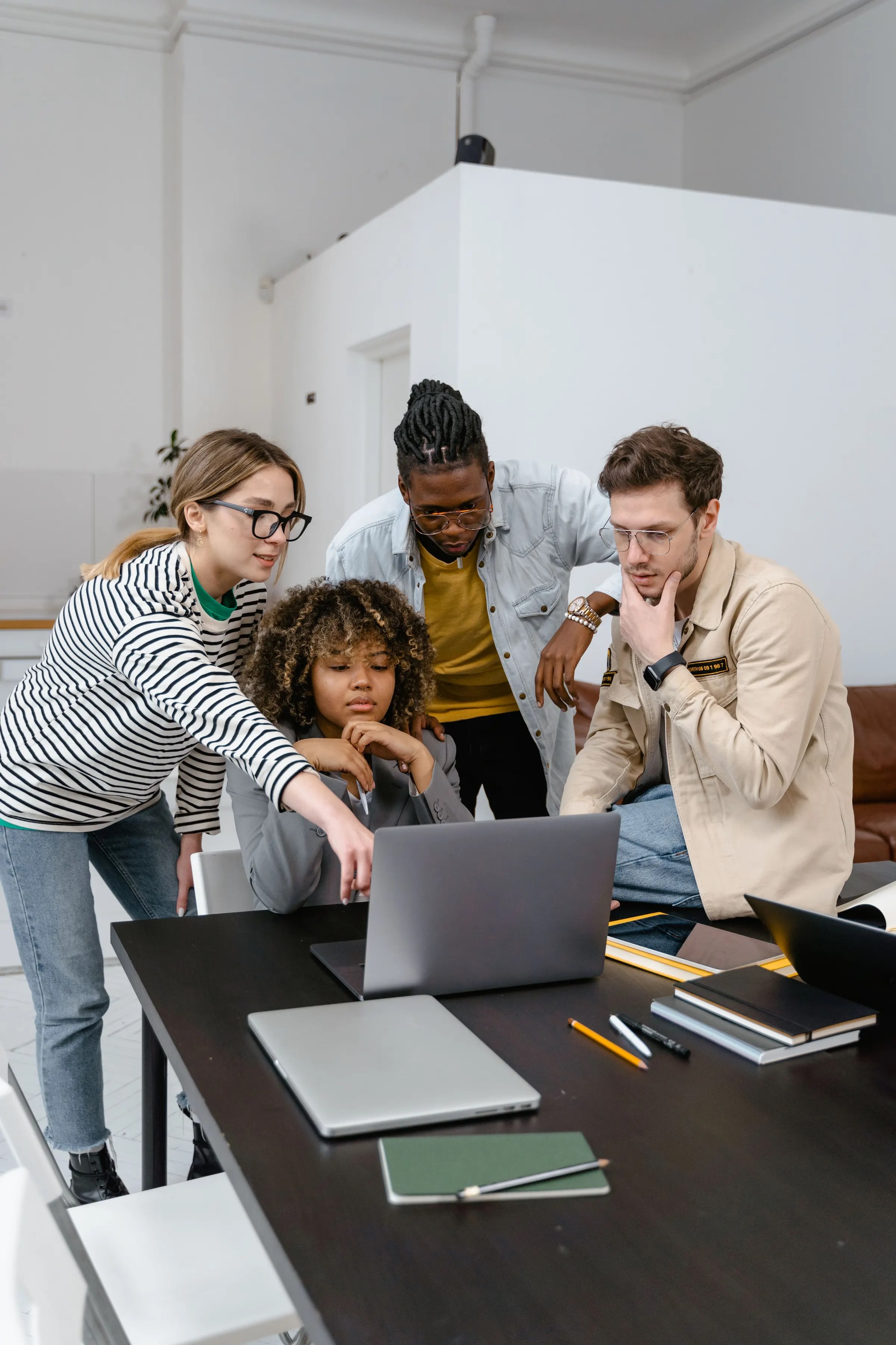 Four colleagues making a schedule together at a laptop