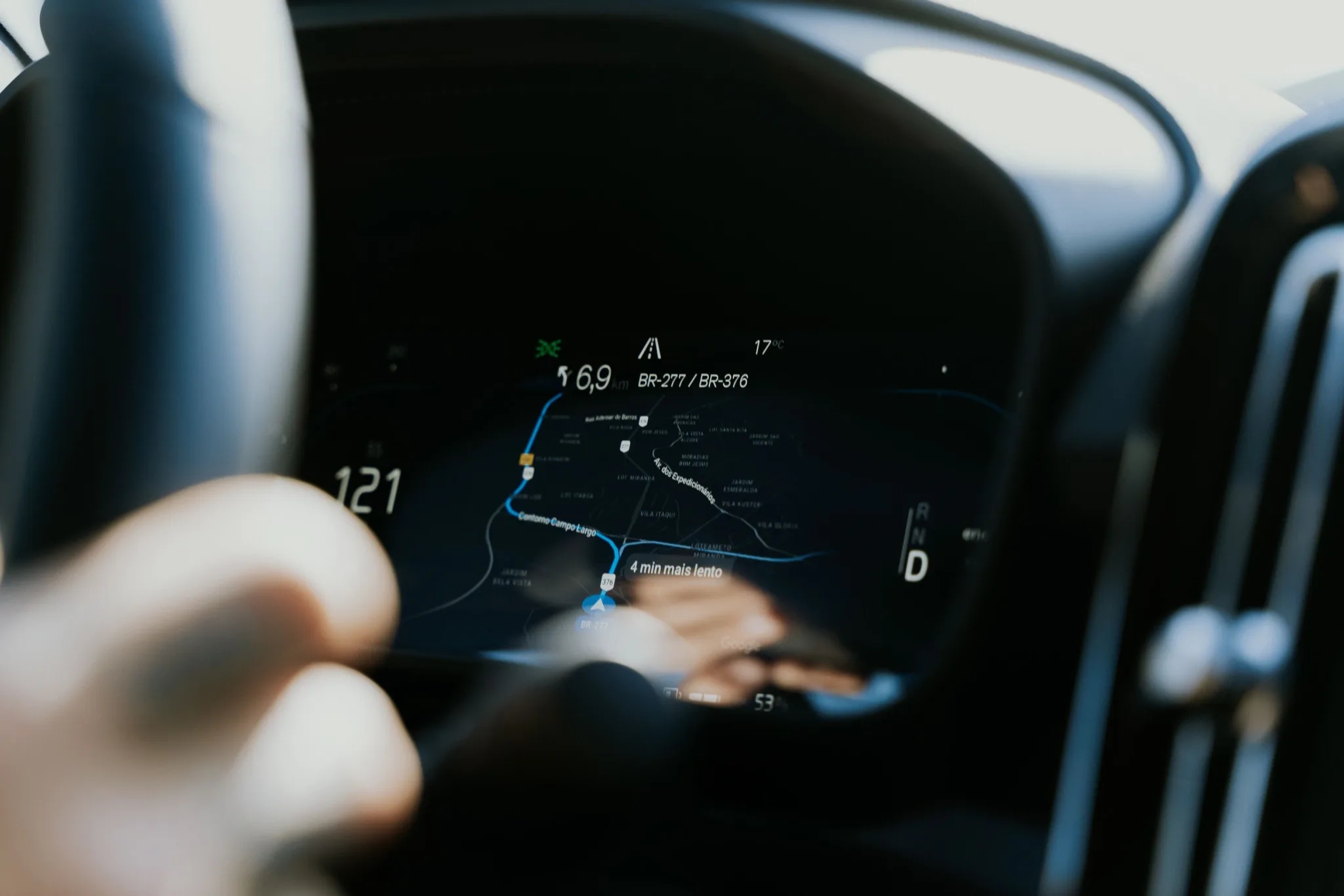 Navigatiekaart op het dashboard van een auto, hand aan het stuur