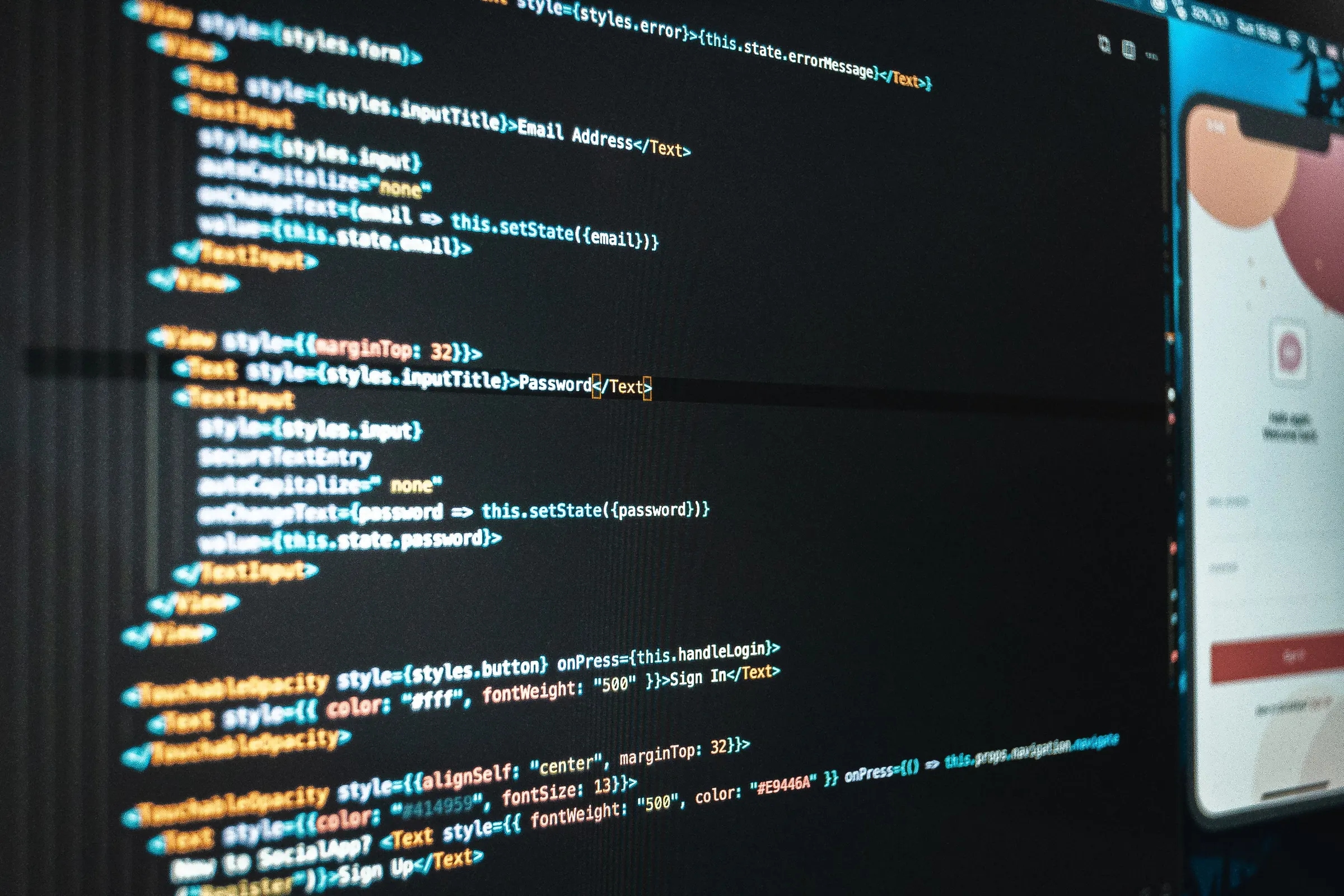Program code for a login screen on a monitor, with the matching app on a phone beside it