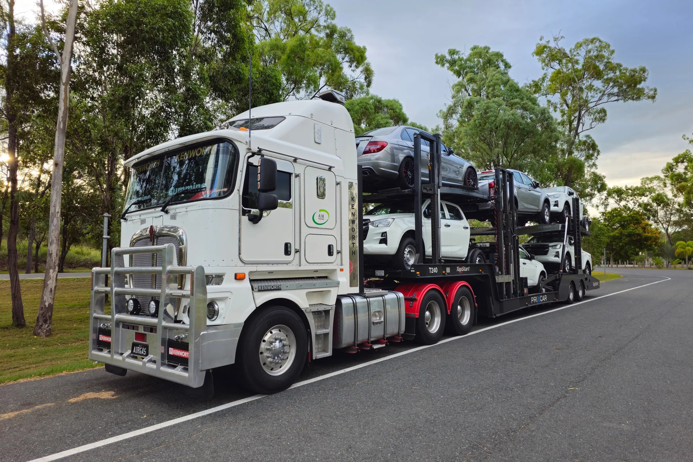 A car transporter with new cars on its decks, parked by the road