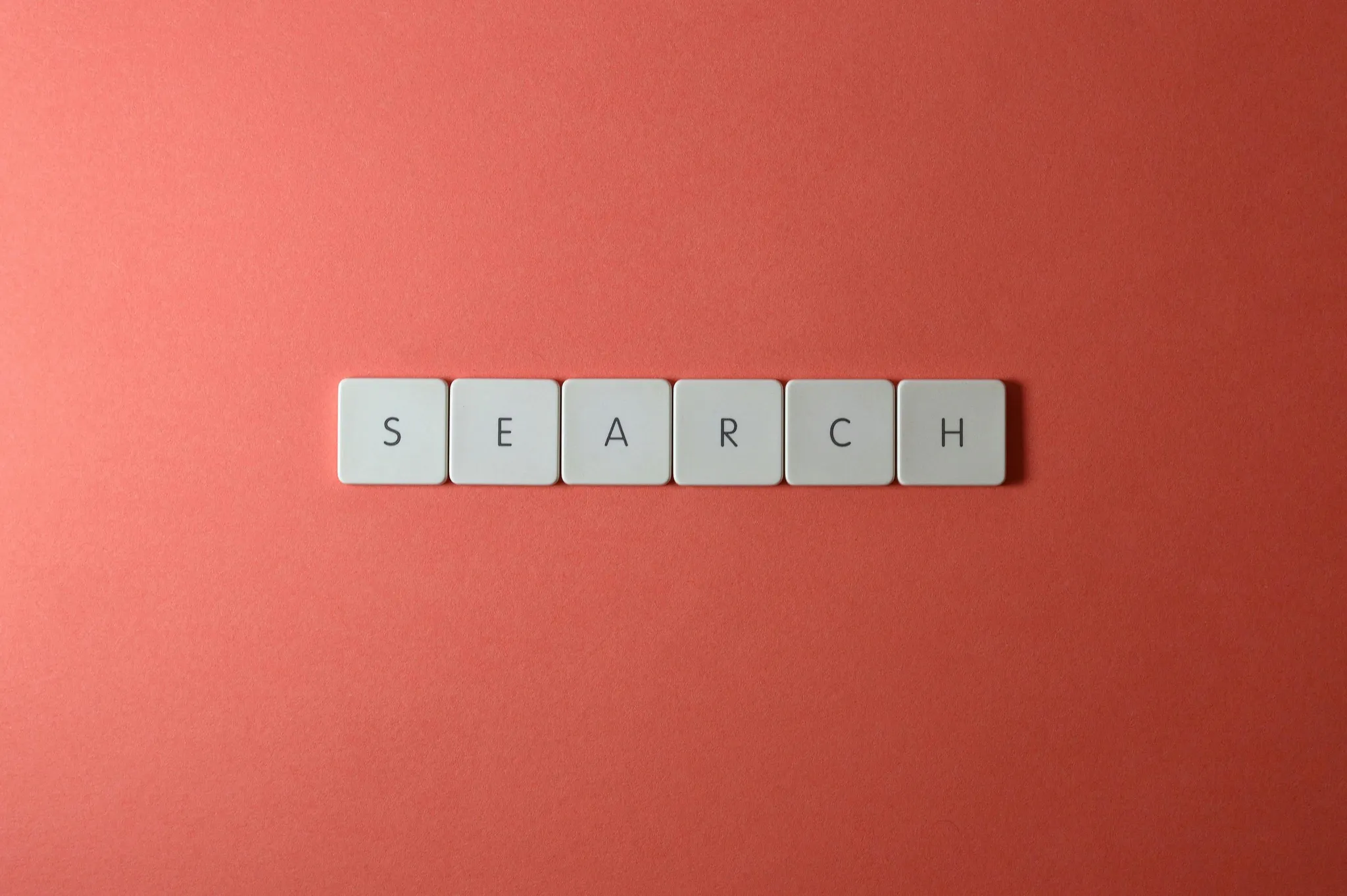 Letter tiles spelling SEARCH on a red background