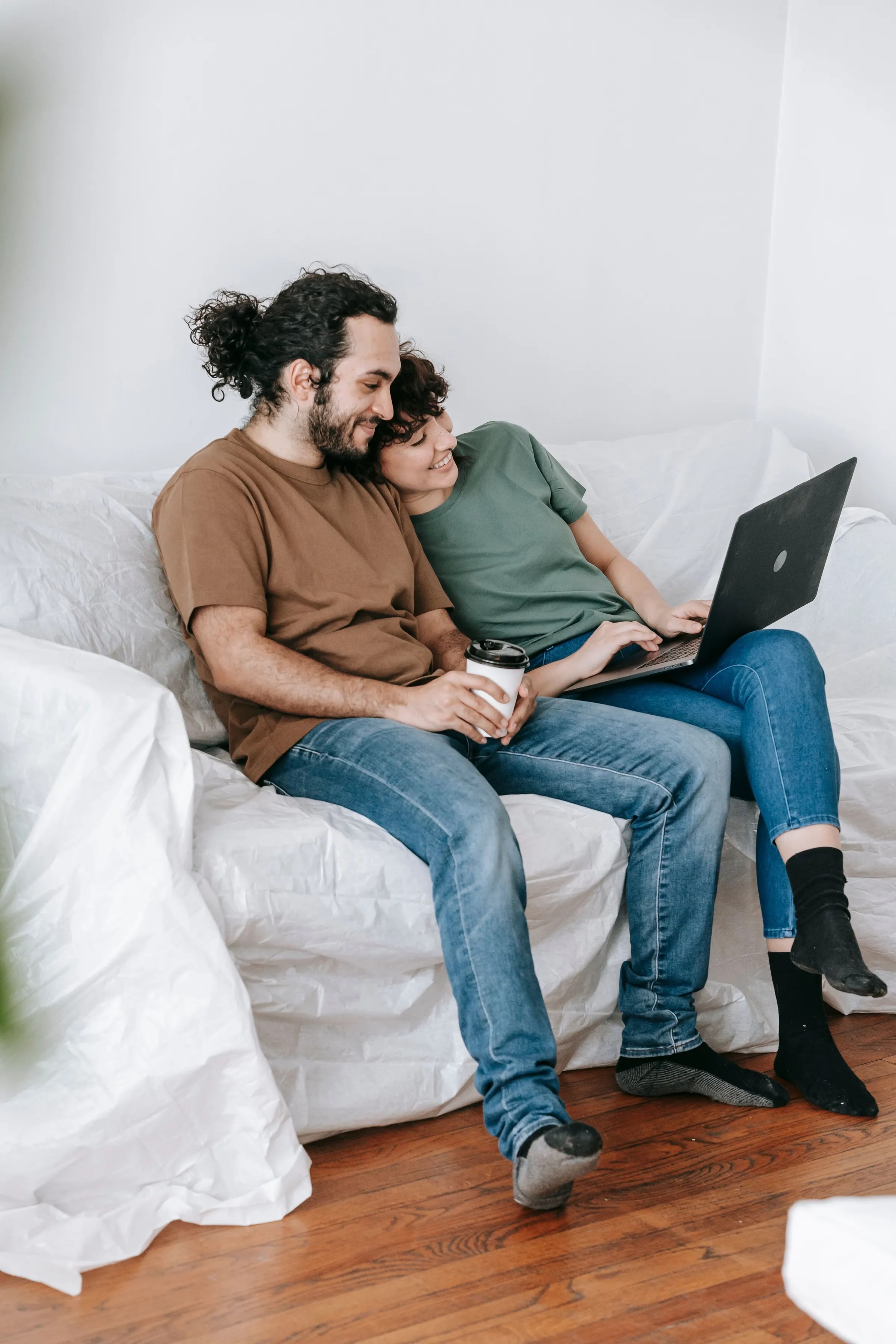 Een stel bekijkt thuis op de bank samen een laptop