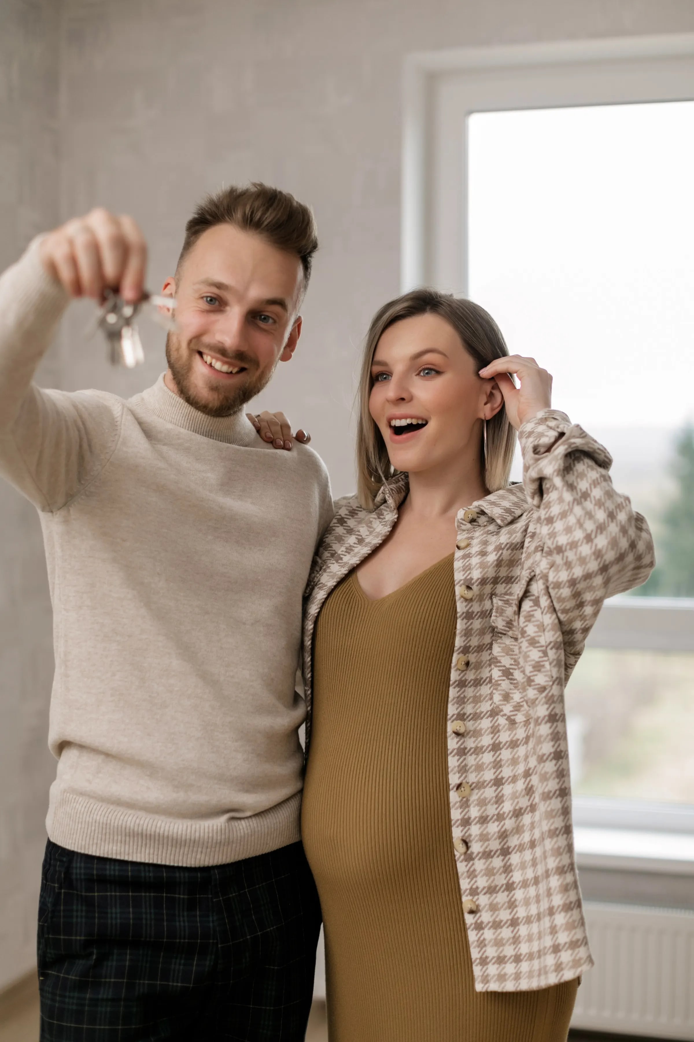 Een stel toont trots de sleutels van hun nieuwe woning