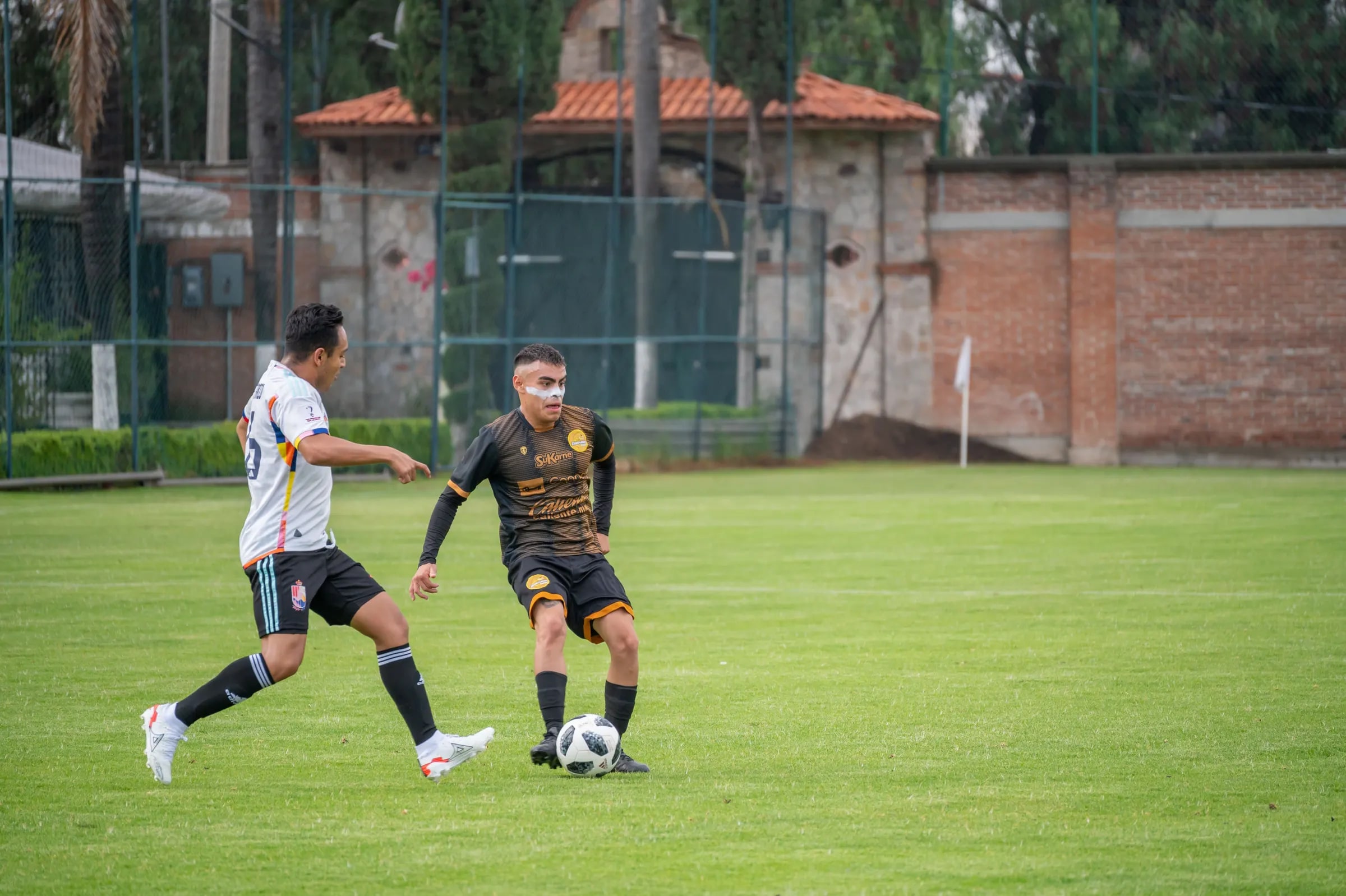 Twee voetballers strijden om de bal op een veld