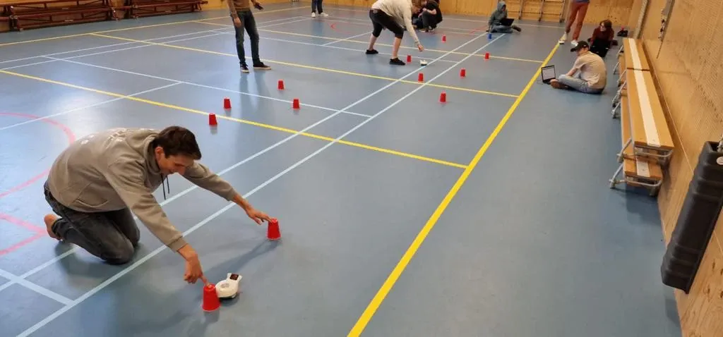 Workshop in een gymzaal waarin Finch-robots met Mendix worden aangestuurd