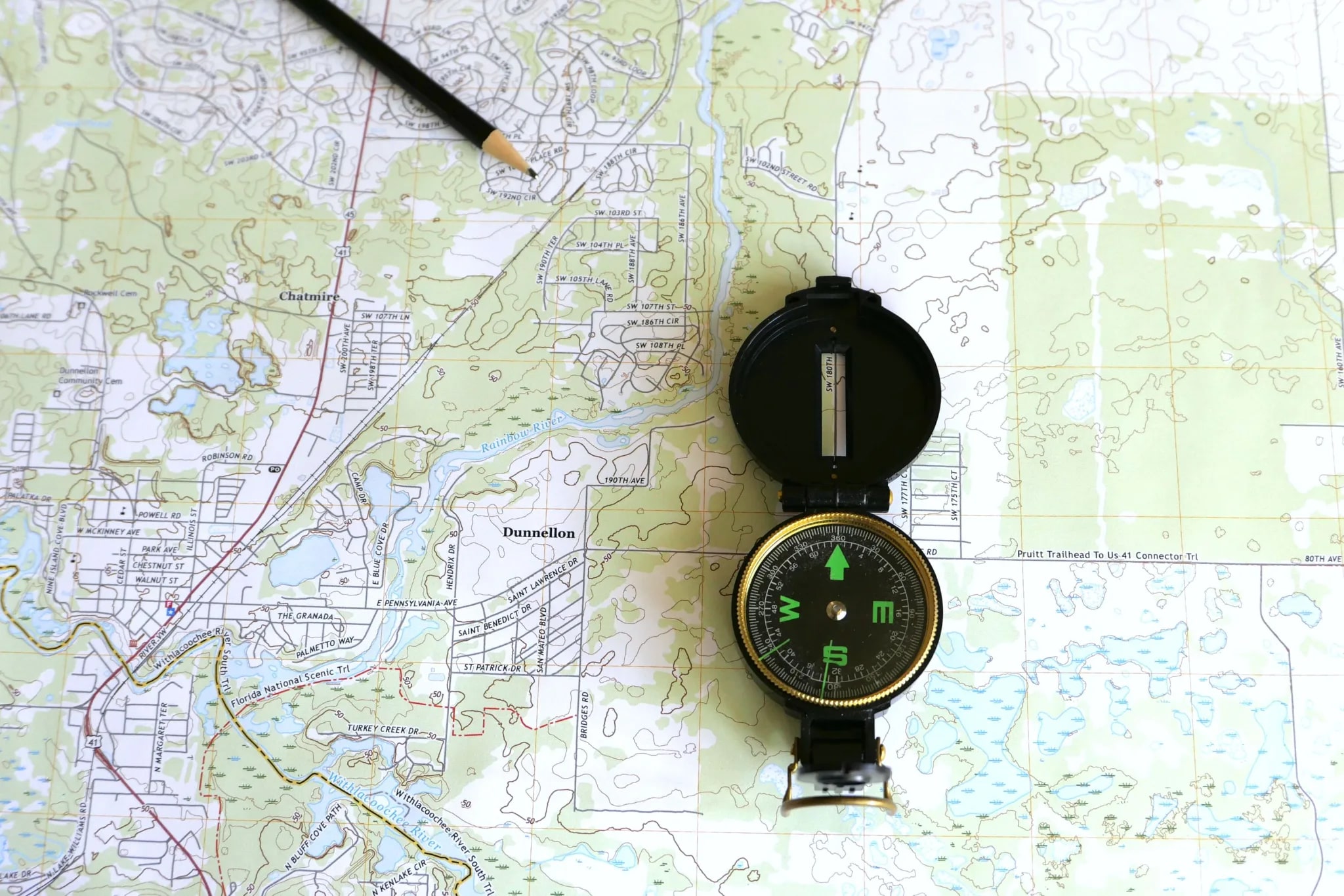 A compass and pencil on a topographic map
