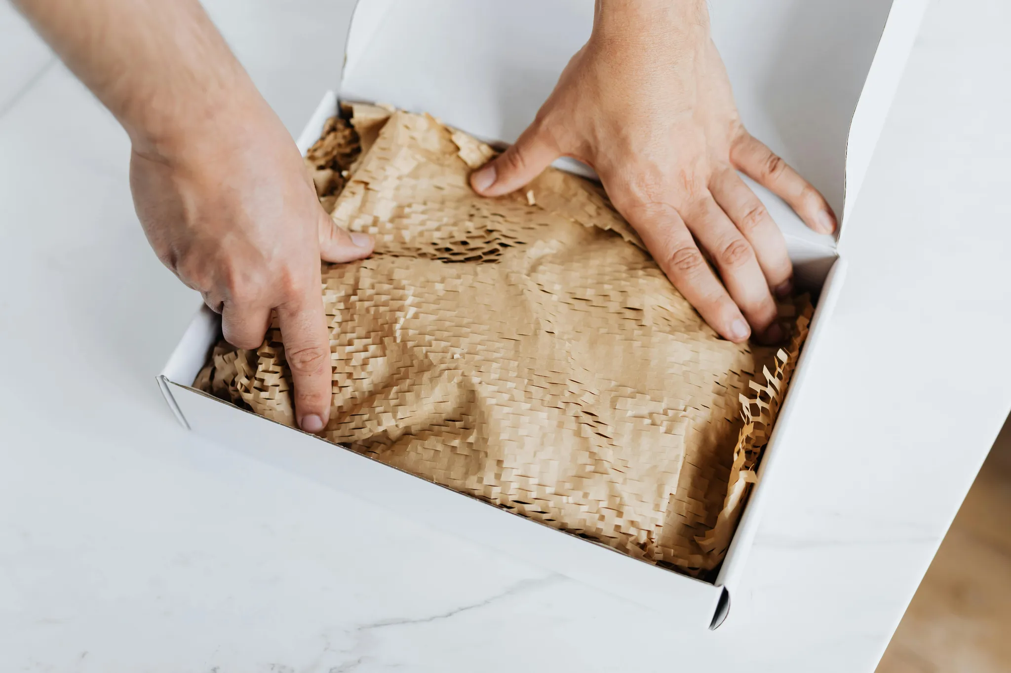 Iemand pakt een doos in met papier
